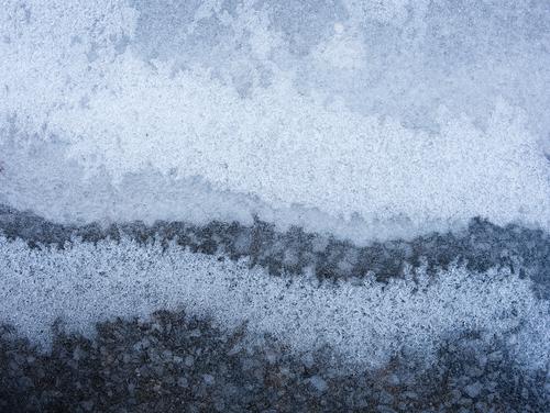 Icy Bands Ice covering asphalt, forming a series of bands of darker and lighter areas where the ice thickness differs.